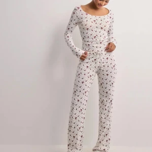 Cute print pyjamas - Tvådelad pyjamas, köpes separat eller tillsammans. Använd vid enstaka tillfälle. Tröjan kan ha ett litet hål vid armbågen pga tjocka stygn vid tillverkning. Printet är med röda rosetter.