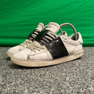 Valentino - Snygga Valentino sneakers i vitt med en iögonfallande svart detalj på sidan. Skorna har snörning och en klassisk design som passar perfekt för en stilren look.
