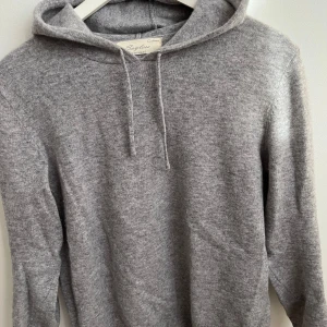 Grå kashmir hoodie från Sayless - Mysig grå hoodie i kashmir från Sayless. Tröjan har en klassisk huva och långa ärmar.