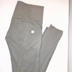 Gröna Freddy wr up byxor  - Snygga gröna byxor med hög midja från Freddy wrup. Byxorna har en tight passform och är tillverkade i ett mjukt och stretchigt material. Perfekta för en stilren look. Inköpspris ca 1390 kr. 