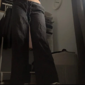 Svarta byxor från Gina Tricot - Snygga svarta byxor från Gina Tricot med en loose passform. Byxorna har en låg midja och är perfekta för en avslappnad stil. Tillverkade i ett bekvämt material som ger en skön känsla hela dagen.