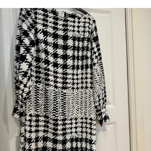 Kollektionen Richard Allan - Snygg svartvit klänning med ett unikt mönster från Richard Allan x H&M. Klänningen har långa ärmar och dekorativa knappar vid ärmsluten. Perfekt för en stilren look 💯🖤🤍 Som ny!!!!!
