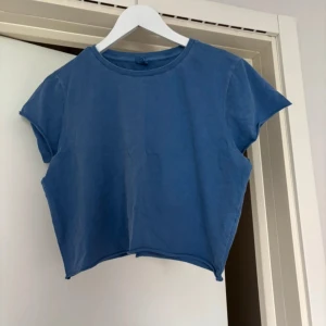 Blå croppad t-shirt - Säljer en blå croppad t-shirt. Den har korta ärmar och en rund halsringning. Perfekt för en avslappnad stil. 💙