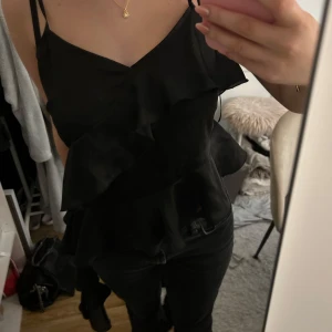 Svart volangtopp - Svart festlig topp med volangdetaljer från Ginatricot. Storlek 36 men passar också 34.💖✨