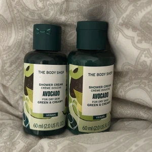 Avocado Shower Cream från The Body Shop - Två flaskor avokado duschkräm från The Body Shop, perfekt för torr hud. Denna veganska duschkräm är grön och krämig, och kommer i en praktisk 60 ml flaska. Perfekt för att återfukta och vårda huden. Ingen av flaskorna är använda