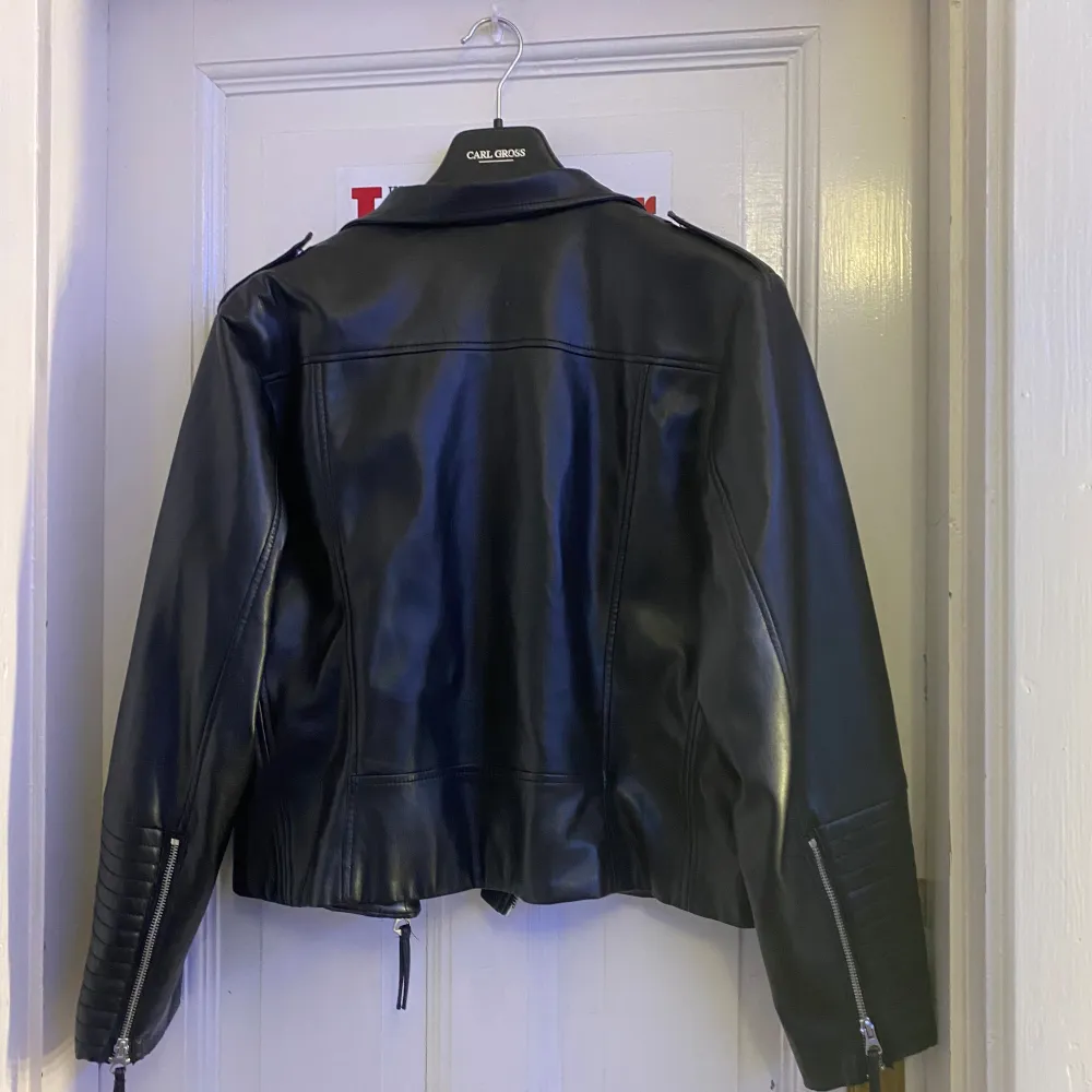 Snygg svart skinnjacka från H&M med dragkedjor och klassisk bikerstil. Jackan har långa ärmar med quiltade detaljer vid ärmsluten och en asymmetrisk dragkedja framtill. . Takit.
