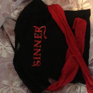 Svart t-shirt med röd text - Snygg svart t-shirt från Dollskill med röd text 'SINNER' på framsidan. Perfekt för en edgy look. T-shirten har en normal passform och korta ärmar.