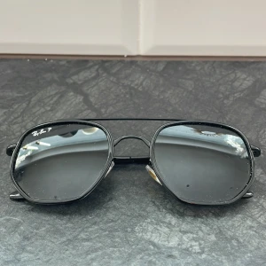 Svarta solglasögon från Ray-Ban - Snygga svarta solglasögon från Ray-Ban med polariserade linser. De har en klassisk design med dubbel brygga och tunna skalmar. Perfekta för att ge en cool touch till din stil.