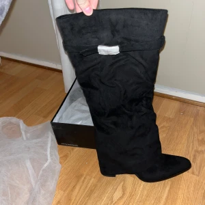 Svarta stövlar med spänne - Snygga svarta stövlar från Azarey i mocka med ett  spänne upptill. Stövlarna har en dragkedja på sidan och passar till många tillfällen. Säljer då jag råkade köpa två och kan inte returnera, därav är de helt oanvända. Köpte för 1 733 kr (vid intresse kan priset diskuteras)💞💞💞