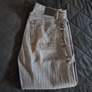 Grå jeansbyxor - Snygga grå jeansbyxor med en klassisk femficksdesign. De har en rak passform och är perfekta för en avslappnad stil. Byxorna har en dragkedjegylf och bälteshällor för extra funktionalitet.