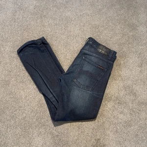 Mörkblå jeans från Nudie Jeans - Riktig snygga Nudie jeans i modellen Grim Tim. Väldigt fint skick o väldigt skön tvätt. Strl 31/32.