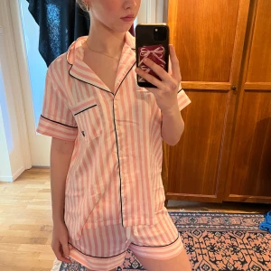 Iconic rosa Victoria secret pyjamas setet - Säljer en till Iconic Victoria secret pyjamas fast i kortärmad och shorts versionen. Setet passar perfekt för vår och sommar när det blir lite värmare. Pyjamas ger en clean girl/ it girl look och gör att vardagen ser lite lyxigare ut💕🥰 Jag har bara använt setet 1 gång och pyjamasen är väl omhändertagen💕 priset kan självklart diskuteras🥰