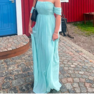 Ljusblå balklänning  - Elegant ljusblå långklänning från Boohoo med offshoulder-design och veckad kjol. Perfekt för speciella och minnesvärda tillfällen💙Endast använd en gång, i nytt skick💕