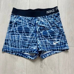 Nike shorts - Blå-vita Träningsshorts från Nike.  Lite slitet Nike märke som man kan se på sista bilden, annars bra skick. 