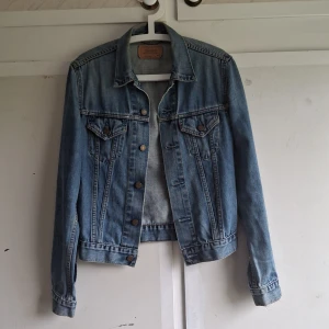 Jeansjacka från Levi's - Säljer en snygg och klassisk jeansjacka från Levi's i storlek M. Jackan är i blå denim med knappar framtill och två bröstfickor med knappstängning. Perfekt för vår och höst! 🧥