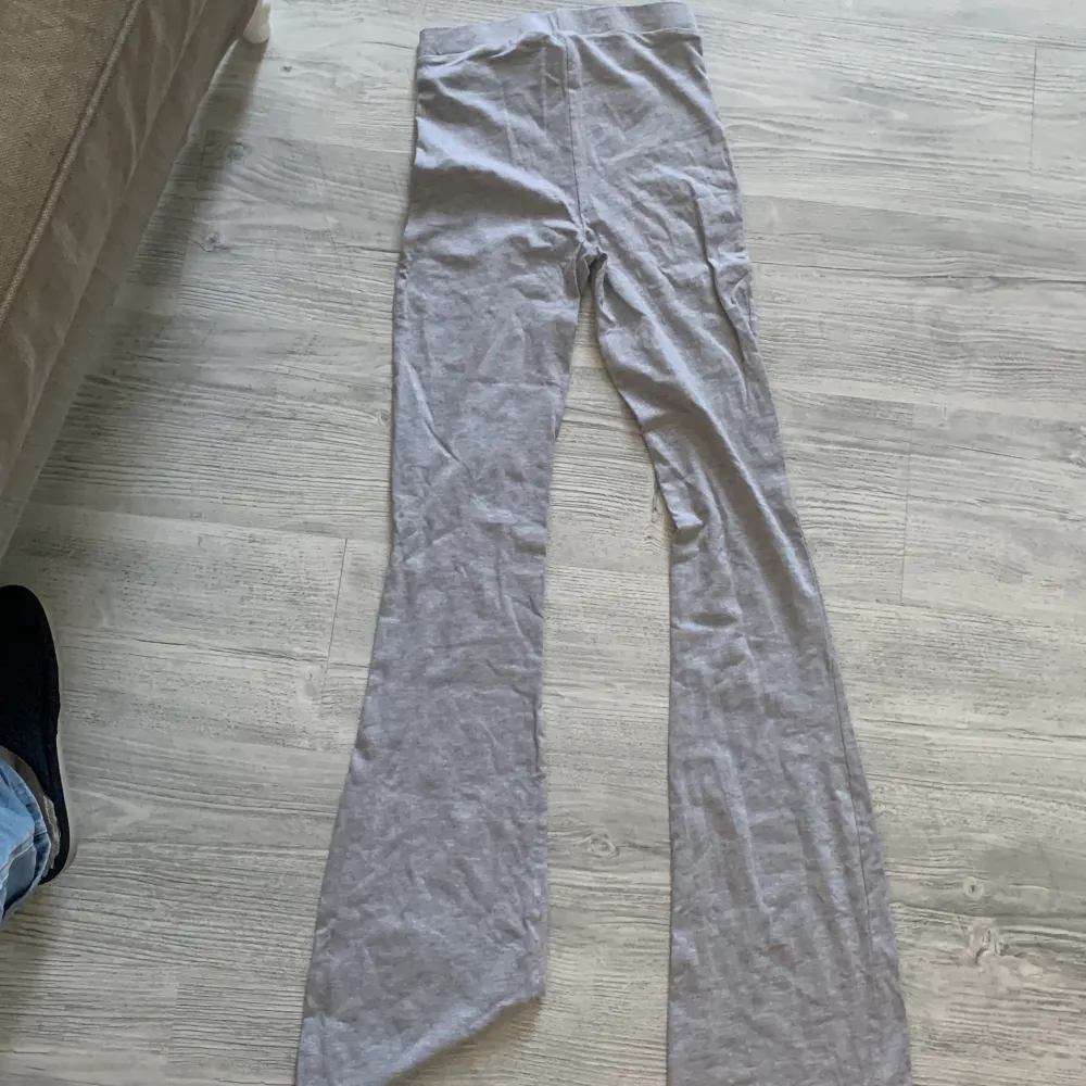 Säljer ett par grå byxor i storlek XS. De har en skön och stretchig passform med utsvängda ben, perfekt för en avslappnad stil. Byxorna är i ett mjukt material som känns bekvämt mot huden.. Jeans & Byxor.