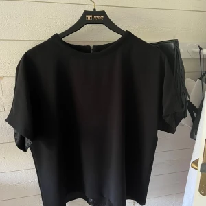 Snygg tshirt tröja  - Säljer en snygg svart T-shirt tröja då den inte kommer till användning. Den har en dragkedja bak i Nacken vilket gör den snyggare💓