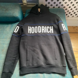 Hoodrich tracksuit  - Hoodrich tracksuit, svart med blå linjer, har en skada vid snörena, använd några gånger 