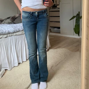 VALERIE JEANS - Säljer ett par snygga blå bootcut jeans. De har en klassisk femficksdesign och en knapp- och dragkedjestängning. Perfekta för en avslappnad vardagslook!