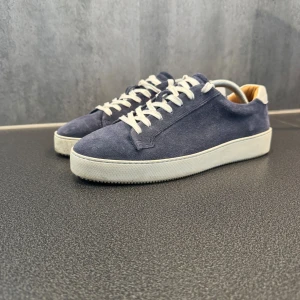 Marinblå mocka skor - Säljer ett par snygga blå sneakers i mocka med vita snören och en vit sula.  Det är ett par Tiger of Sweden skor i väldigt bra skick. Pris kan diskuteras🙌🏽