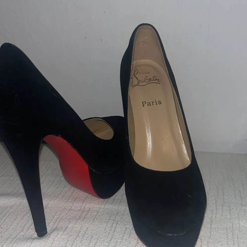 Säljer ett par eleganta svarta pumps från Christian Louboutin. Skorna är i mocka med den ikoniska röda sulan. De har en hög klack och rund tå. Ser nästan helt nya ut och är inga fel på dem. Säljer då dem inte passar längre😔inget kvitto däravlågtpris. Skor.