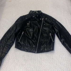 Svart skinnjacka  - Okej skick svart skinnjacka med knappar och dragkedjor från hm