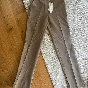 Byxa med sidoslits  - Oanvänd byxa med prislapp kvar. Finns matchande kavaj till. Höga i midjan och skönt material. Byxorna är perfekt längd  på mig som är 169cm 