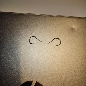 Enkla svarta örhängen - Säljer ett par enkla och stilrena guldiga örhängen. De har en minimalistisk design och är perfekta för vardagsbruk eller att matcha med andra smycken. Passar till alla tillfällen!