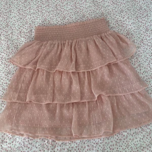 Volangkjol med smock - Rosa volangkjol med smock från Lindex Kids. Färgen på kjolen är lite mer rosa i verkligheten än på bilden. Storlek är 158/164, passar xs/s