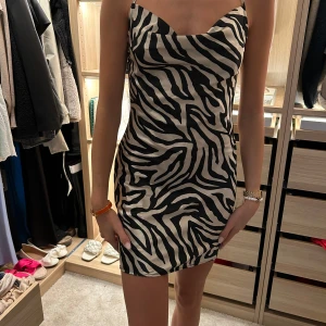 Zebra klänning  - Jättefin satinklänning med djup rygg från hm. Använd en gång, köpt för 199kr och säljer för 119kr