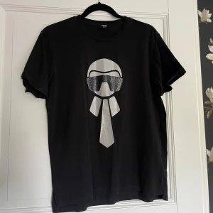 Fendi t-shirt - Cool t-shirt från Fendi, köptes för längesedan men har bara hängt i garderoben. Svart med silverglittrigt motiv, text på baksidan, nyskick. ☺️