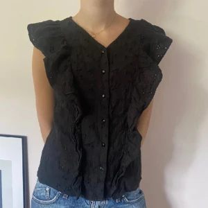 Svart volangtopp  - Så fin svart topp med volanger. Knappar i mitten. Köpt secondhand men i bra skick🩷🩷