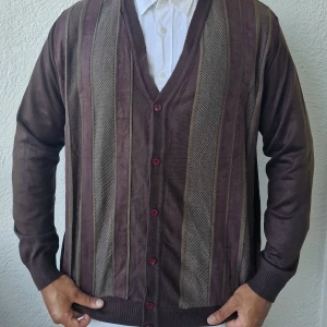 Brun kofta från Hugo Boss - Säljer en snygg brun kofta från Hugo Boss. Den har ett randigt mönster med olika nyanser av brunt och beige. Koftan är långärmad och har knappar framtill. Perfekt för höst och vinter!