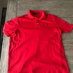 Röd Ralph lauren piké - Säljer denna feta Polo ralph lauren pikén perfekt nu till sommaren! Skick 10/10. Är öppen för alla sorts frågor om du skulle vara intresserad.