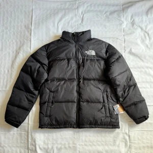 Oanvänd The North Face - 1996 Retro Nuptse Dunjacka Svart XL - Jackan är oanvänd och har lappar kvar. Jackan är perfekt nu inför hösten och vintern!  Storleken är XL och färgen är svart