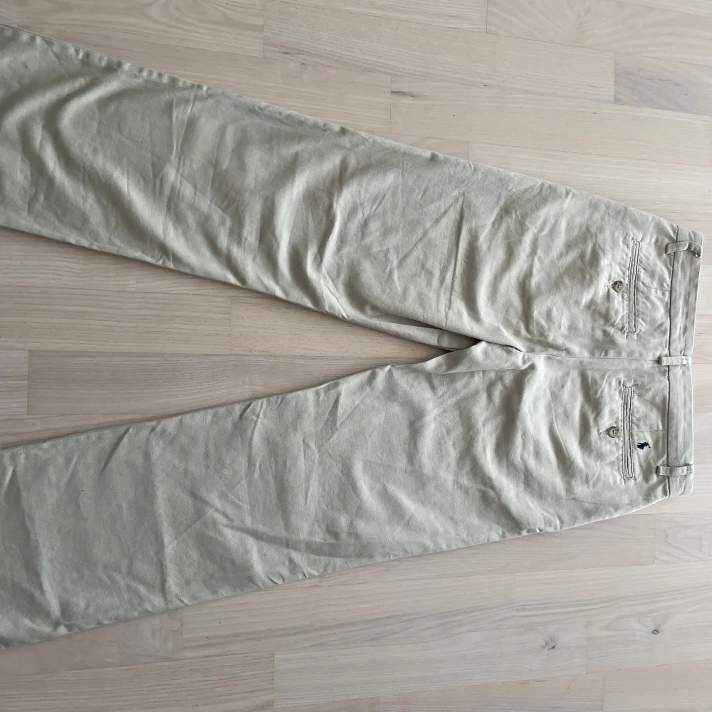 Säljer ett par stilrena beige chinos från Ralph Lauren i bra skick. De är midwaist och har en normal. Materialet är bomull, vilket gör dem bekväma och lätta att bära. Byxorna är i storlek 164-170/14 år 😄🔥. Jeans & Byxor.