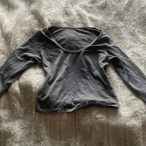 Grå långärmad topp - Säljer en enkel och stilren grå långärmad topp. Den är perfekt för vardagsbruk och har en bekväm passform. Materialet känns mjukt mot huden och den har en rund halsringning. Passar bra till både jeans och kjol!