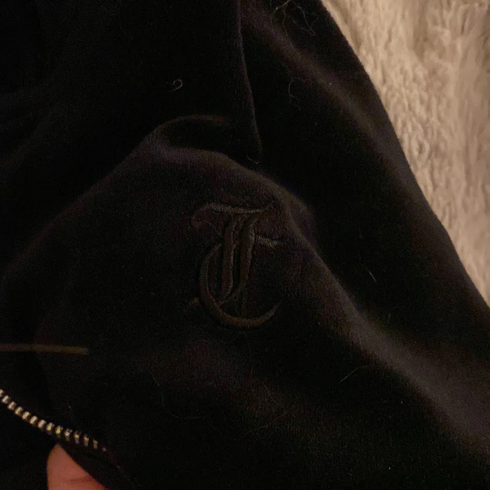 Säljer en snygg svart jacka från Juicy Couture. Den har en dragkedja framtill och ett broderat 'J' på ärmen. Perfekt för en casual look! inga defekter(nypris:800kr). Hoodies.