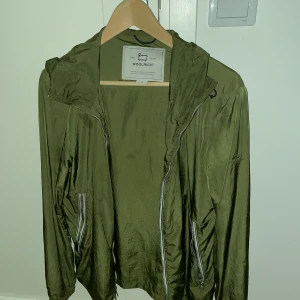 Woolrich windbreaker  - Säljer min Woolrich Windbreaker i nyskick pga av att den aldrig används. Perfekt nu inför hösttider och passar med många outfits. Nypris cirka 3500kr.