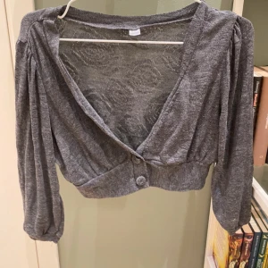 Grå bolero - Söt grå bolero/ kofta. Storlek xs men passar mig som är s också. Ganska bra skick lite nopprig som man kan se på bilderna men inget man tänker på