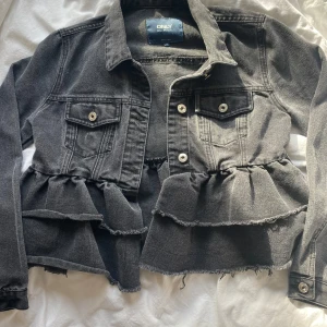 Jeansjacka  - Grå jeansjacka med fina volanger, aldrig använt
