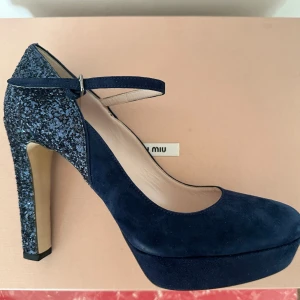 Miu Miu Mary Janes i mocka - Miu Miu Mary Janes i mocka med glitterklack.  Mycket bra skick med enbart tecken på användning under sulan. Kommer med originalkartong och dustbags.