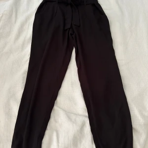 Svarta byxor med knytband - Säljer ett par svarta byxor i storlek S. De har en hög midja och ett snyggt knytband framtill. 🖤
