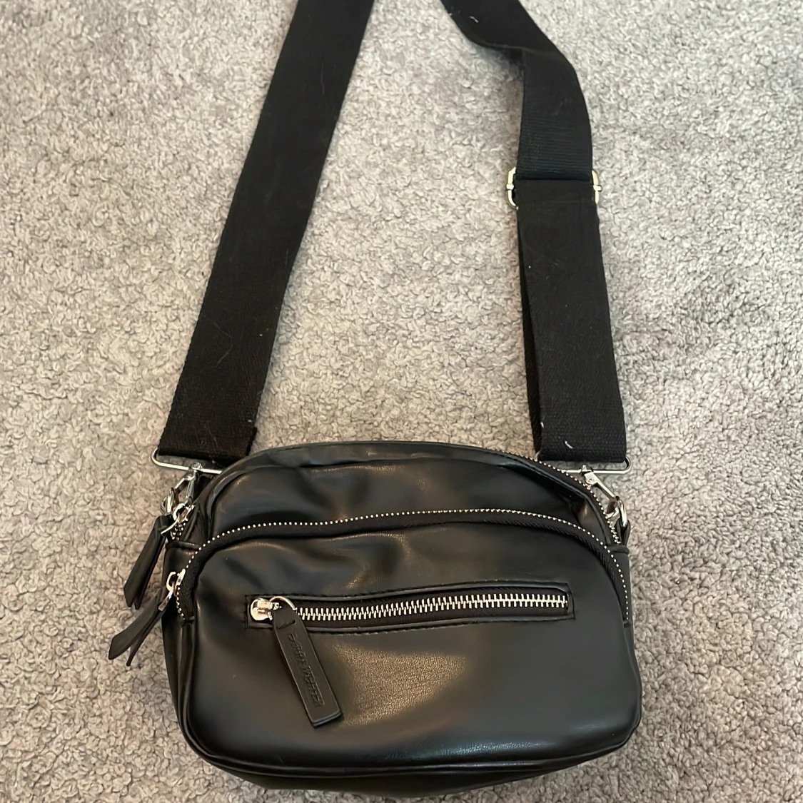 Svart axelväska med dragkedjor