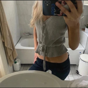 Grå kofta med knytband - Säljer en jätte gullig grå kofta med knappar och knytband i midjan. Man kan reglera både midjan och längden genom att stoppa upp den som jag har gjort på några av bilderna! Vet inte exakt storlek men som sagt går den att reglera tror typ xs-L eller större!😁😊