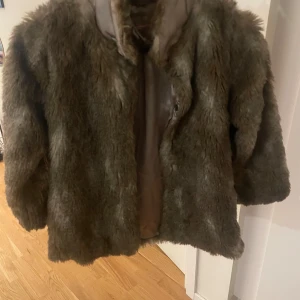 Brun pälsjacka - Säljer en mysig brun pälsjacka med långärmad design. Perfekt för kyliga dagar och ger en lyxig känsla. Jackan har en klassisk look och passar bra till olika outfits.
