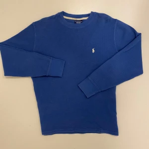 Blå tröja från Polo Ralph Lauren - Säljer en blå långärmad tröja från Polo Ralph Lauren. Tröjan är tillverkad i 100% bomull och har en liten broderad logga på bröstet. Perfekt för en avslappnad stil. Perfekt skick använd Max 3 gånger perfekt julklapp, skriv vid minsta fråga eller funderingar 