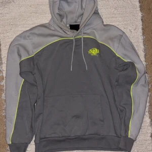 Syna World  - Säljer en sällsynt hoodie från Syna World med neongula detaljer. Riktigt snygg och bekväm! Använd 2 gånger. Storlek S men passar oxå till M. Köpt från UK