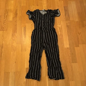 Svart och vit randig jumpsuit från Lindex - Snygg svart jumpsuit med vita ränder från Lindex. Den var storlek 134 och passar barn som är 8-9 år gamla. 💕