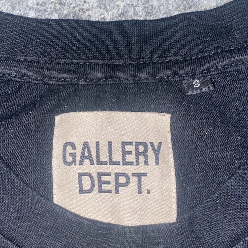 Snygg svart t-shirt från Gallery Dept. med tryck 'DEPT.' på framsidan och detaljerat tryck på baksidan. Perfekt för en stilren och avslappnad look.. T-paidat.